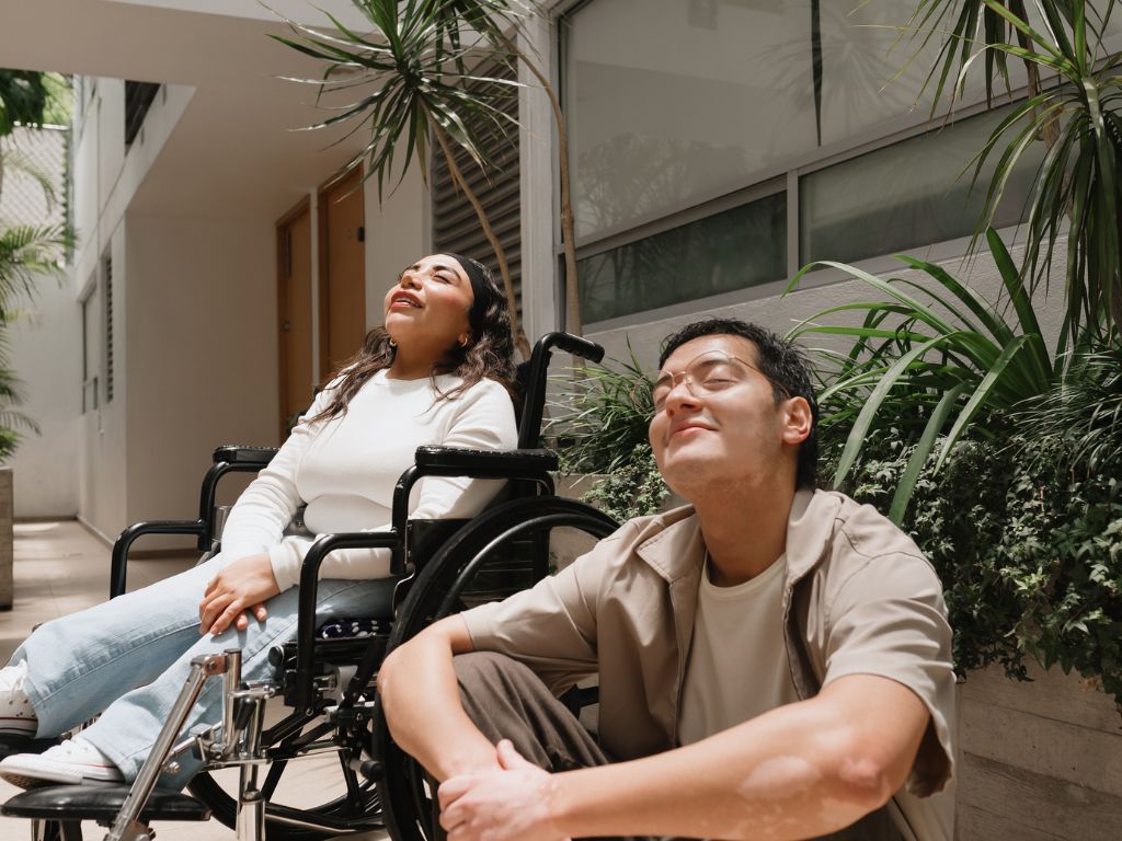 two people sitting outside of an apartment building