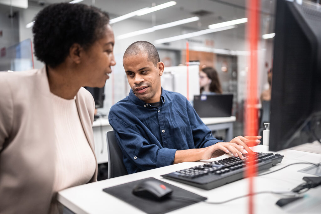 two people talking at a computer lab